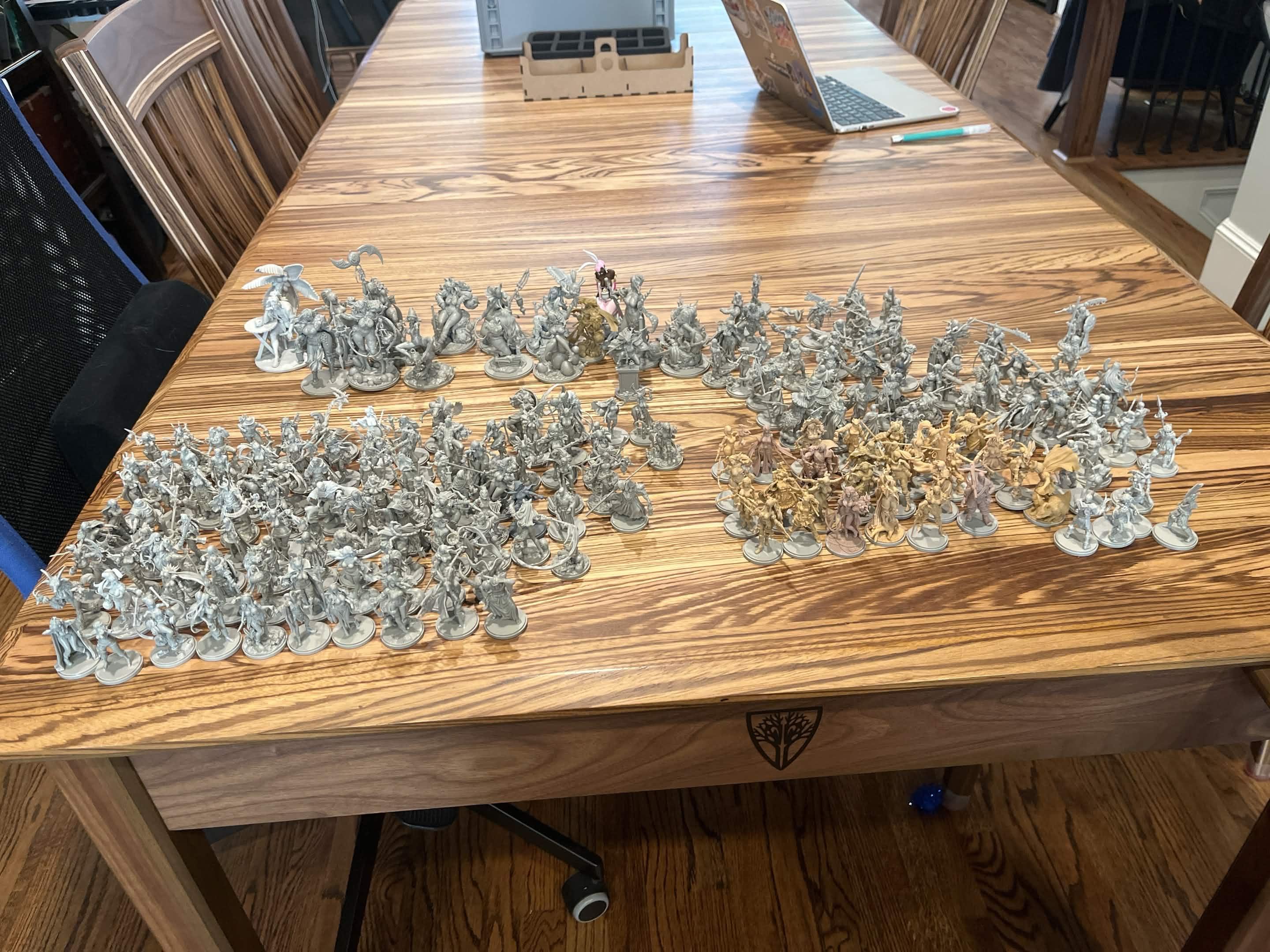 A table with over 100 unpainted, assembled miniatures