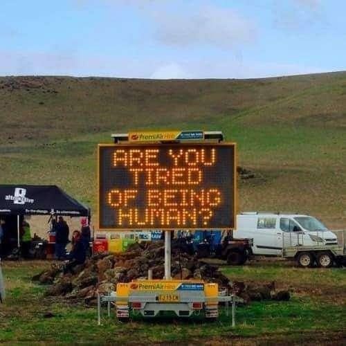 Photo of a road sign that was modified to say "Are you tired of being human?"