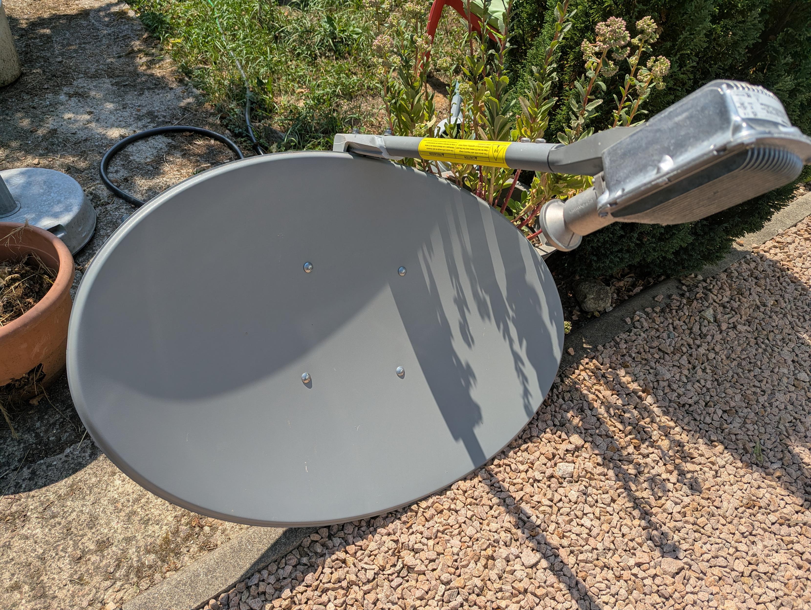 Front side of an approximately 75 * 55cm parabolic dish, with an extremely heavy (what looks like a) heat sink.

The extra width is perfect for my dual 5.8GHz receiver attached horizontally.