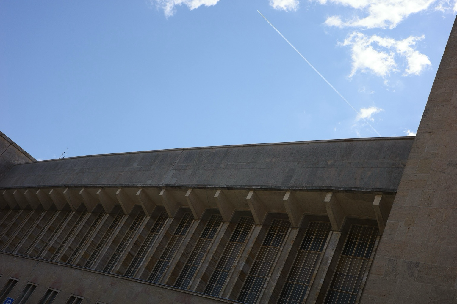 Tempelhof airport with a plane con trail.