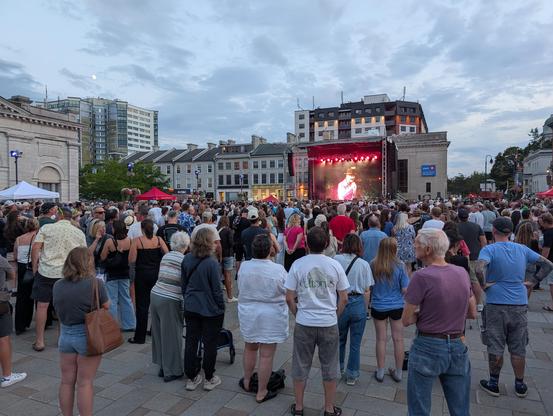 A crowd of people in Kingston, Canada watching the replay of a 2016 Tragically Hip concert.