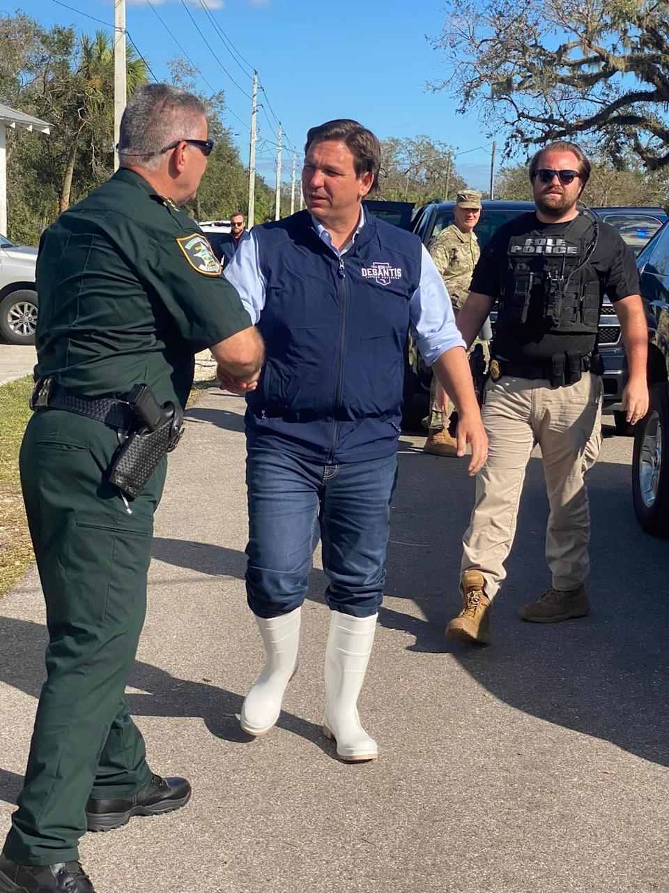 Picture of Ron DeSantis wearing knee high white rubber boots.