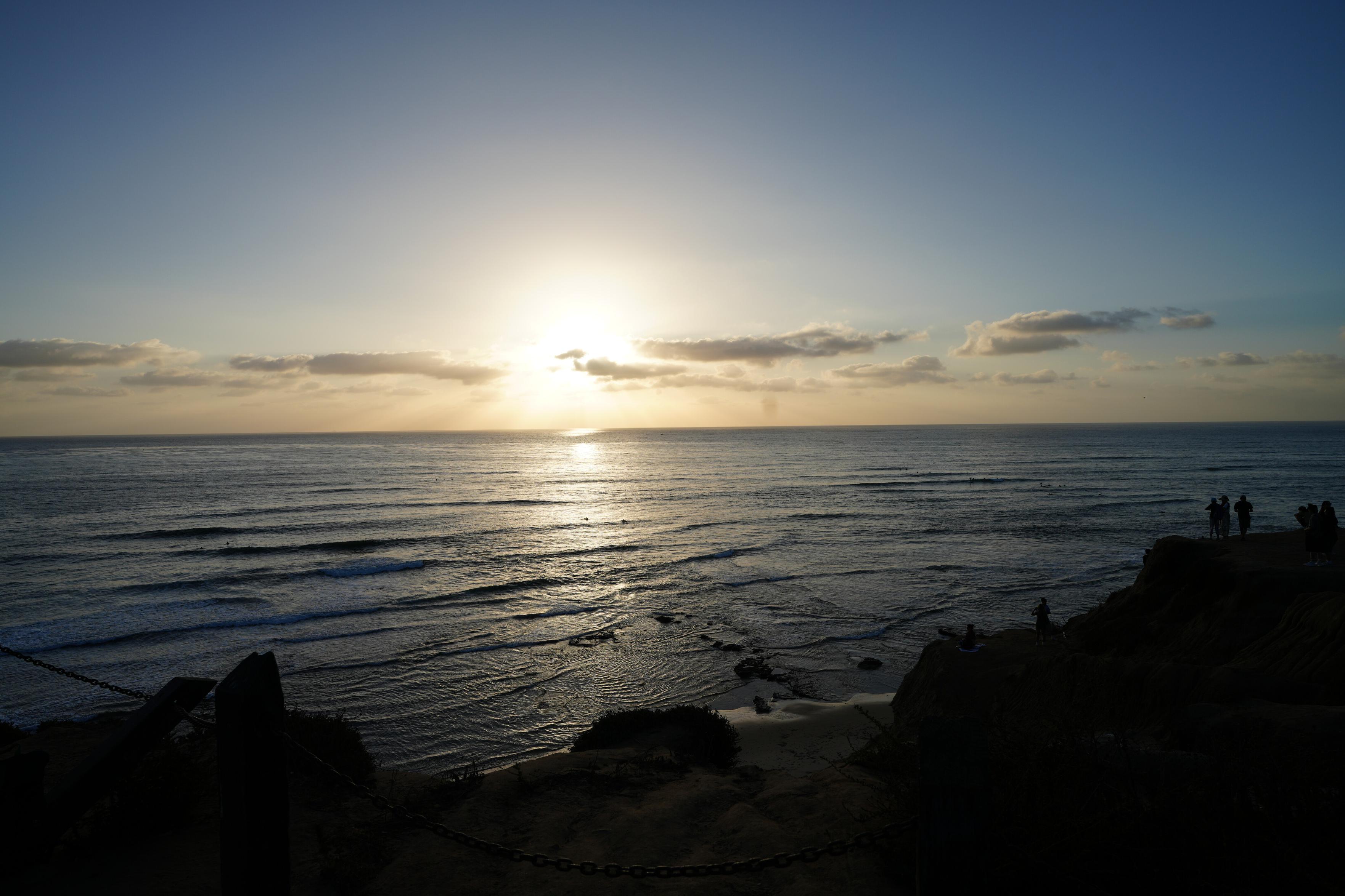 Photo of a sunset over a beach, still mostly day.