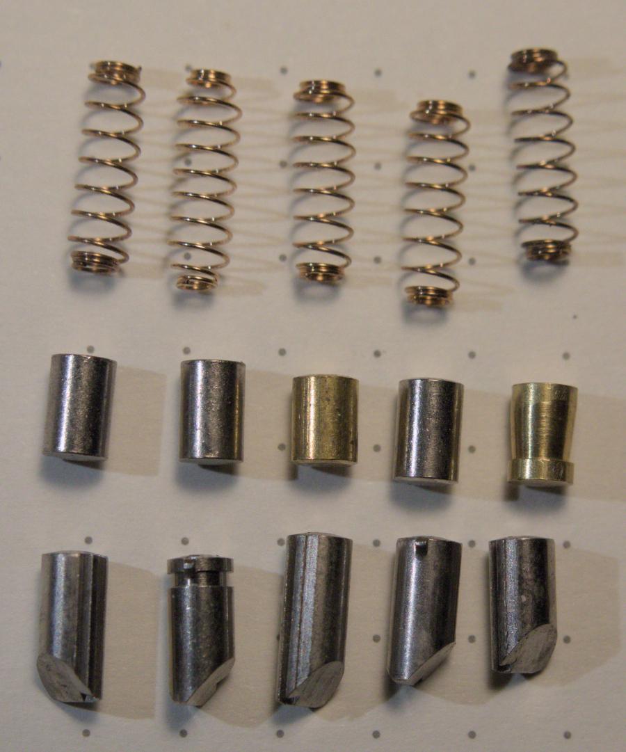 The pins and springs from a Medeco Biaxial. The pins are a mix of one brass standard (for a zero lift pin), three stainless steel anti-drill pins and one brass mushroom pin.
The key pins have offset chiseled tips, and a set of gates for the sidebar. Each pin has a single false gate and one true gate. One pin has an anti-decoding grove to prevent rotation from decoded without being picked, which prevents bumping attacks.