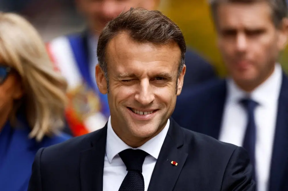 Macron smiling and winking.