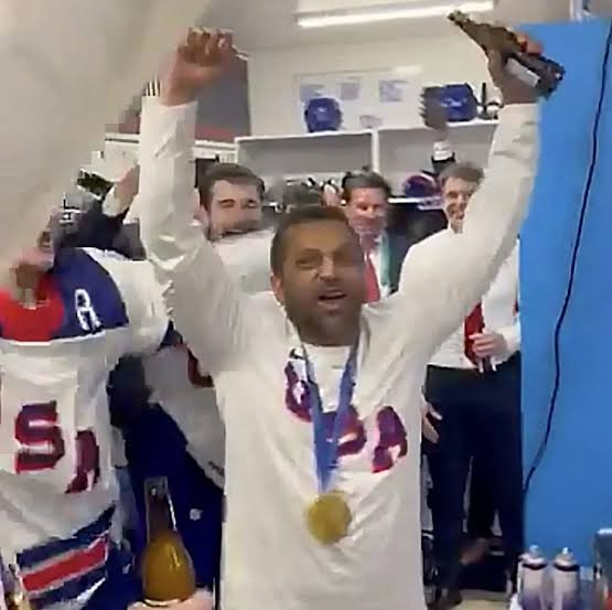 photo of kash patel celebrating in a locker room, with a beer in hand