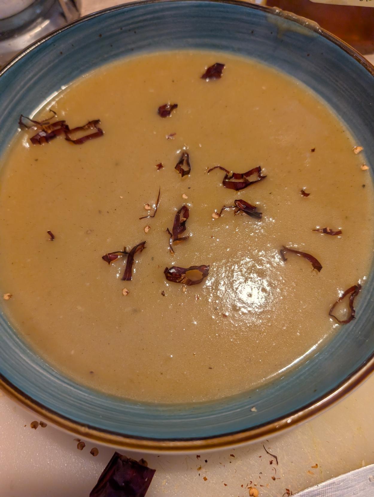 A bowl with squash soup sprinkled with cakabrian chilies