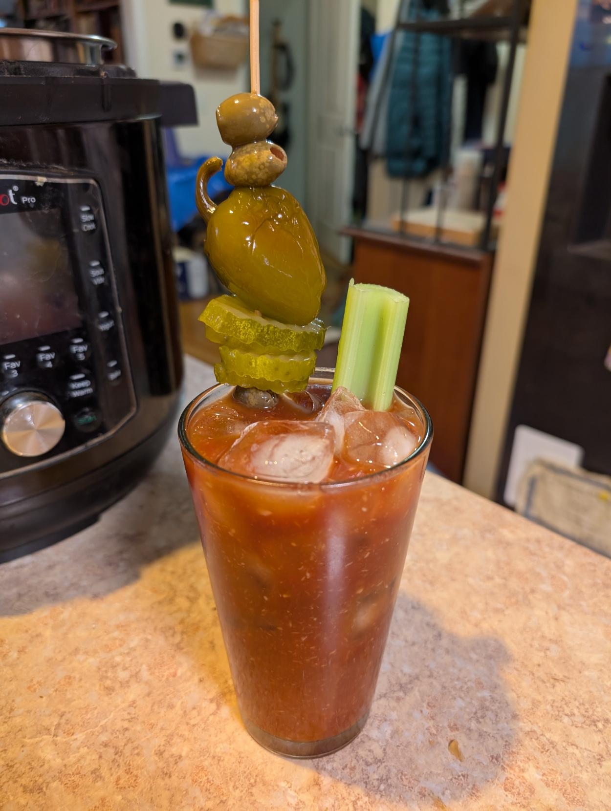 A bloody Mary garnished with celery, pickles, pickled cherry pepper and olives