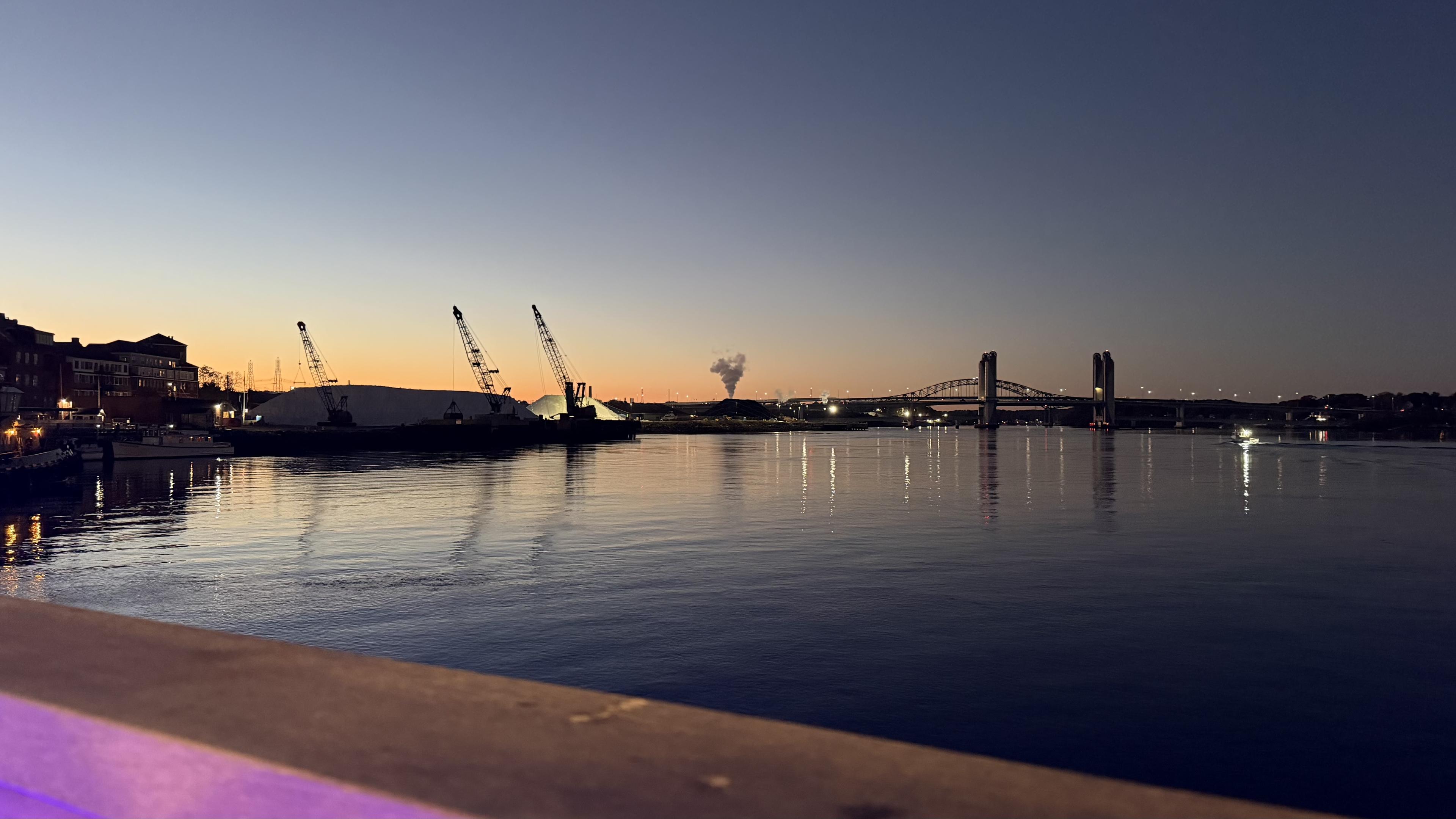 Photo from Portsmouth looking over the water of the Piscataqua river looking towards Maine with the sun down, but the sky still lit up a bit
