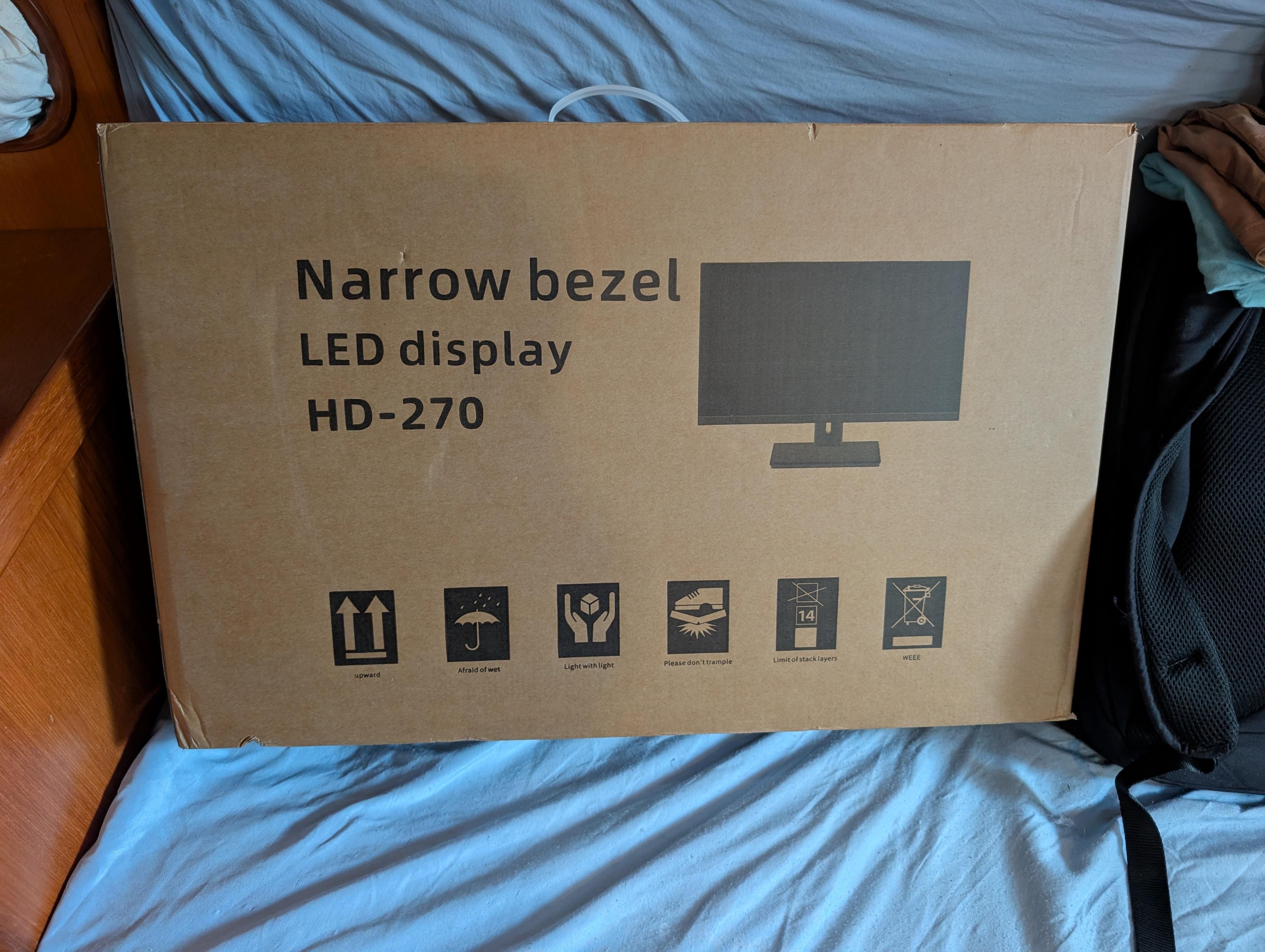 A cardboard box with a picture of a generic computer monitor on it along with various shipping symbols.